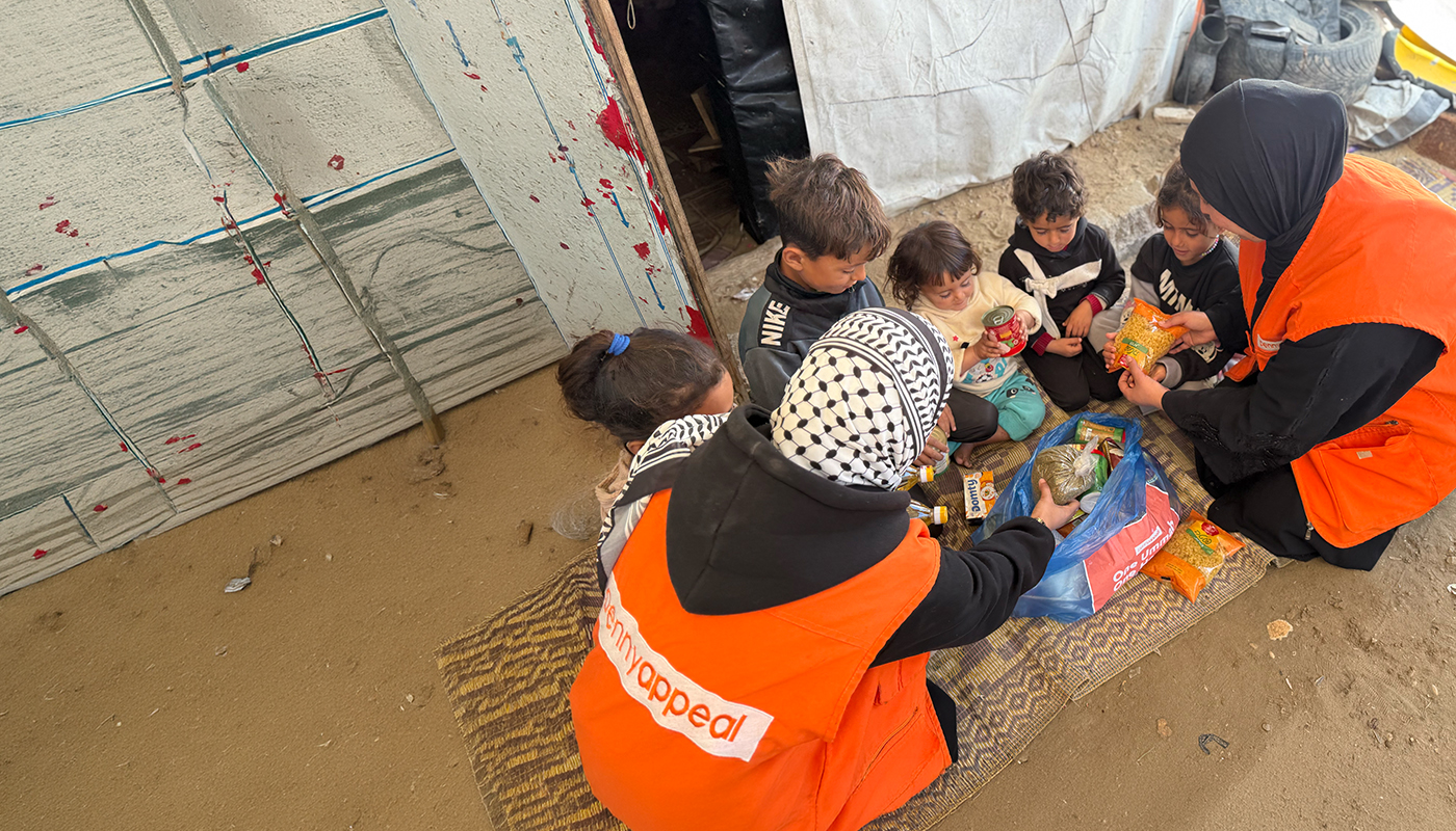 A group of children being given food by Penny Appeal workers.