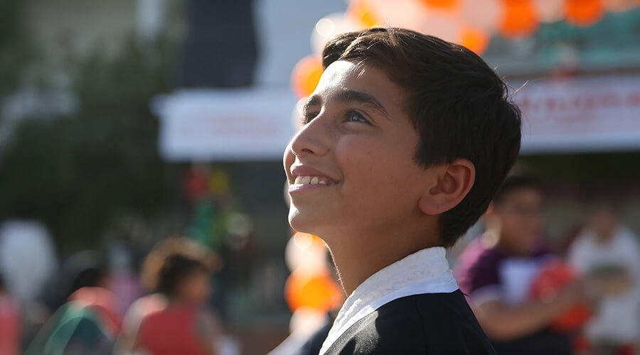 A boy smiles while facing away from the camera.