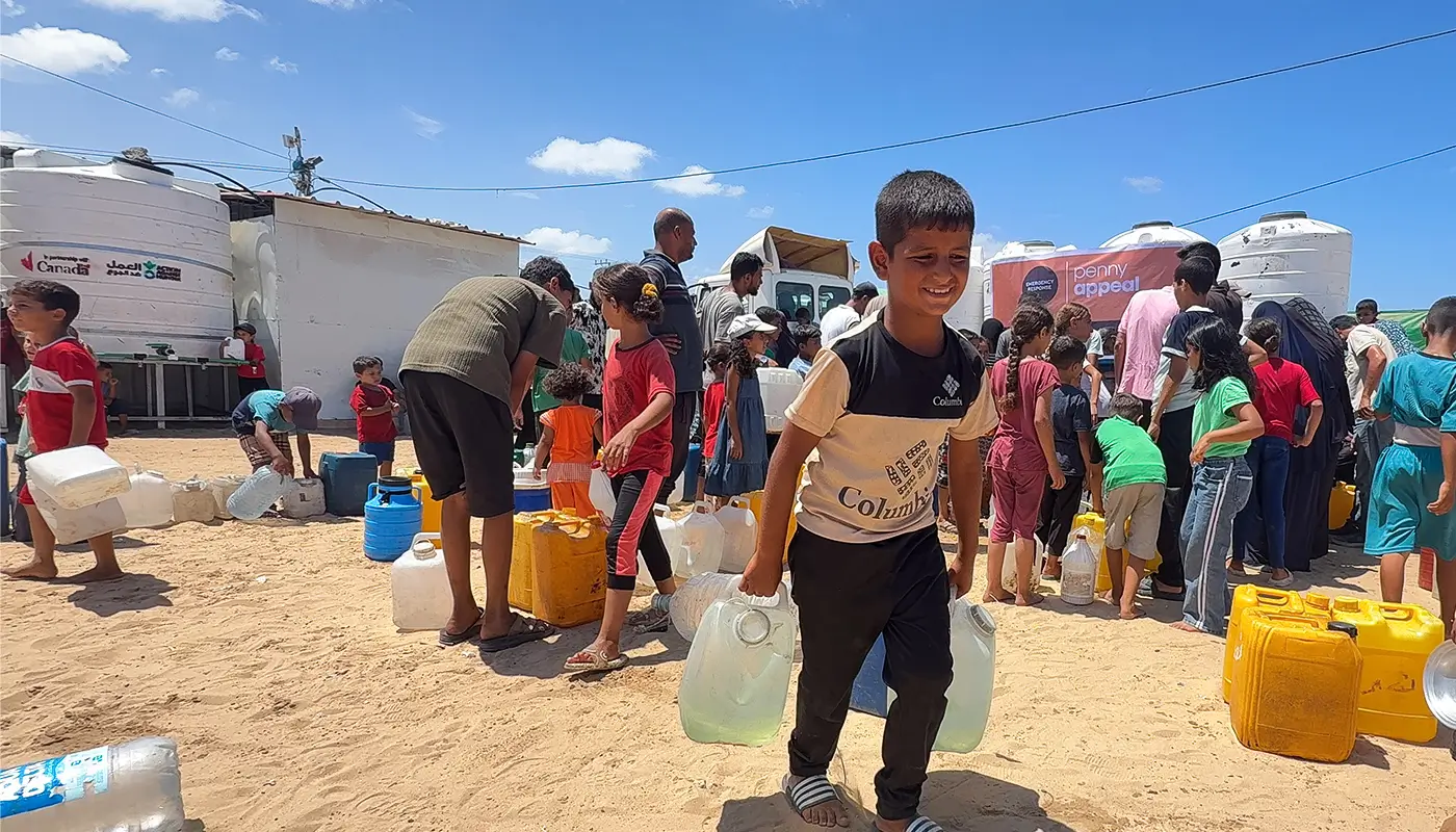 A child carries big bottles of water.