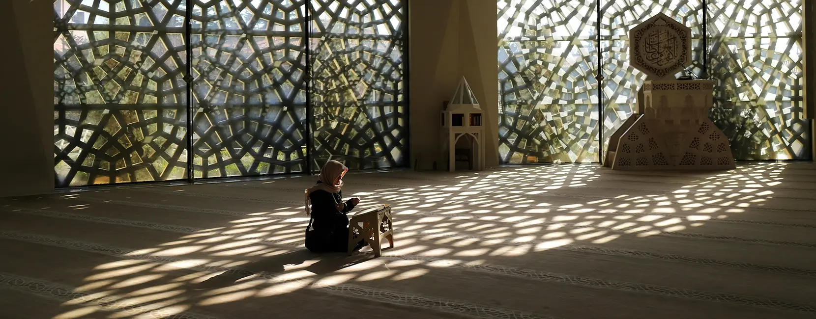 A young girl prays inside of a mosque.