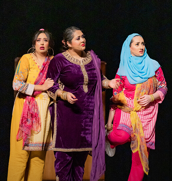 A cute bear mascot in an orange outfit performing a dance or greeting, with a digital backdrop in the background displaying challenges and goals.
